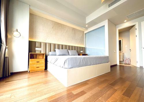 a bedroom with a large bed and a wooden floor at Stylish 2BR Apartment ARC100 Surabaya City Centre with Balcony by Le Ciel Hospitality in Surabaya