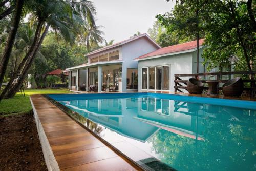 an exterior view of a house with a swimming pool at Banyan Tree Pool Villa at Surya River Thane in Pālghar