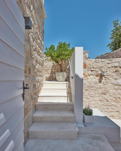 a staircase leading up to a house with a stone wall at Orange Tree House in Vis