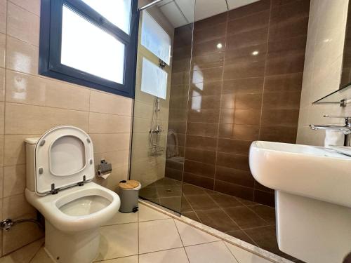 a bathroom with a toilet and a sink and a shower at Al Dana villa in Fujairah