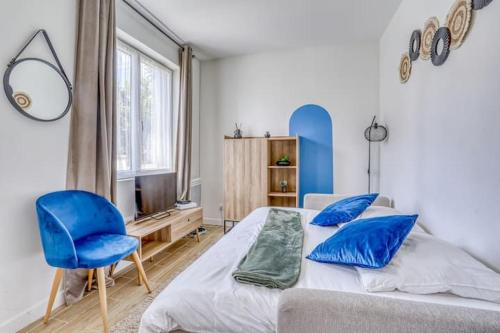 une chambre avec un lit et une chaise bleue dans l'établissement Emmanuel INN 2, à Pierrefitte-sur-Seine
