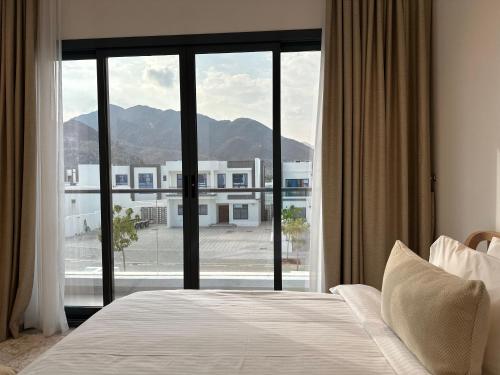 a bedroom with a bed and a large window at Al Dana villa in Fujairah