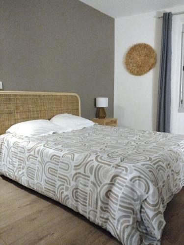 - une chambre avec un lit et une couette blanche et noire dans l'établissement appartement cosy, à Romans-sur-Isère