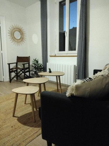 - un salon avec deux tables et un canapé dans l'établissement appartement cosy, à Romans-sur-Isère