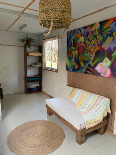 a living room with a couch and a painting at Cabaña entre parras in Curacaví