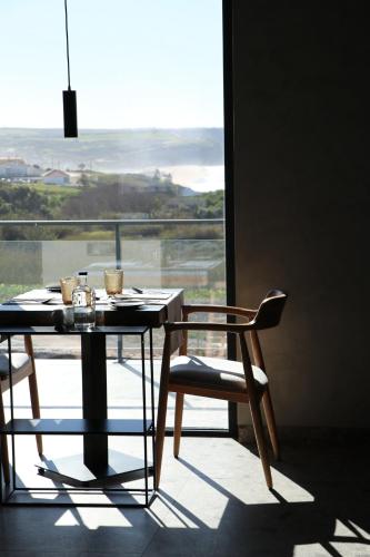 a table and chair in front of a large window at Santa Cruz - Movement & Nature House in Santa Cruz