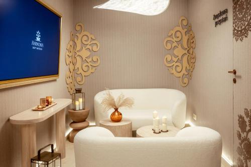 a living room with a white chair and a tv at Złoty Groń Resort & Spa in Istebna
