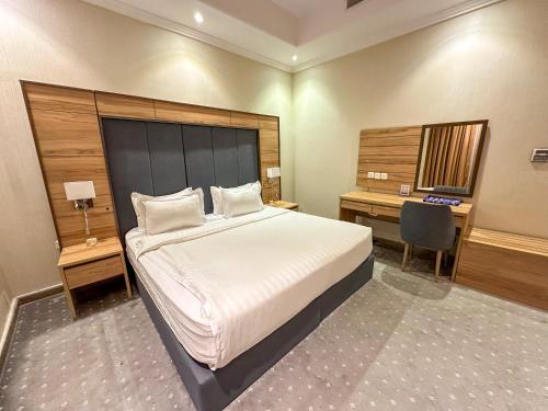 a bedroom with a large bed with a desk and a bed sidx sidx sidx sidx at لافنت بارك للشقق المخدومة - إقتصادي in Jeddah