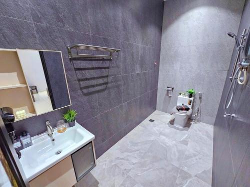 une salle de bain avec un lavabo et des toilettes dans l'établissement JPP l 角头间豪华私人KTV房泳池Switch火锅炉BBQ麻将机可睡26人5分钟到Austin, à Johor Bahru