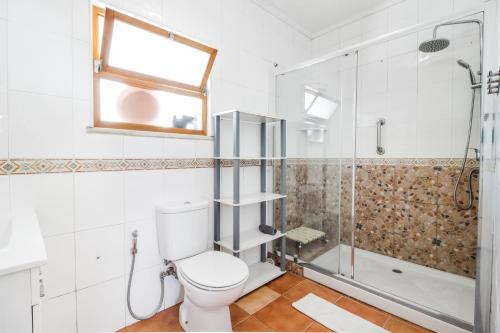 a bathroom with a toilet and a shower at Saude Beach House in Costa da Caparica