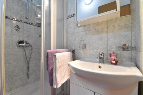 a bathroom with a sink and a shower at Cosy Medulin apartments with terrace in Medulin