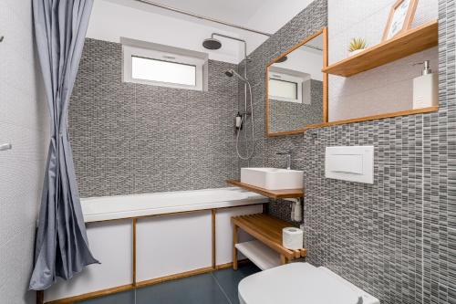 a bathroom with a shower and a sink and a mirror at Cozy Apartment - Swimming Center, Airport & Therme SPA in Otopeni
