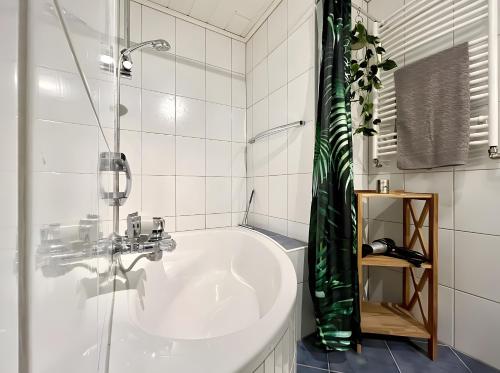 a white bathroom with a tub and a shower at Ate´s kleine Welt in Brilon