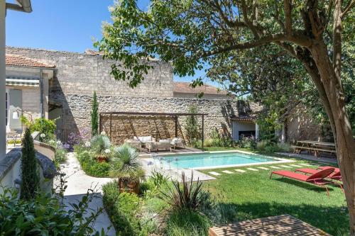 une cour arrière avec une piscine et une maison dans l'établissement Loue maison de maitre en Camargue, à Saint-Laurent-dʼAigouze