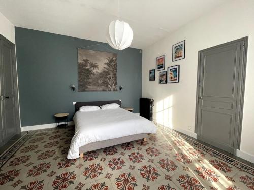 une chambre avec un lit et un tableau au mur dans l'établissement Loue maison de maitre en Camargue, à Saint-Laurent-dʼAigouze