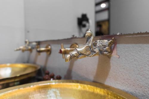 a bathroom sink with a brass faucet on a counter at Dalai-La Boutique Hotel in Kathmandu