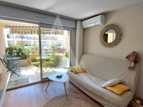 d'un salon avec un canapé et un balcon. dans l'établissement T2 sur zone pietonne, a quelques pas des plages, à Sète