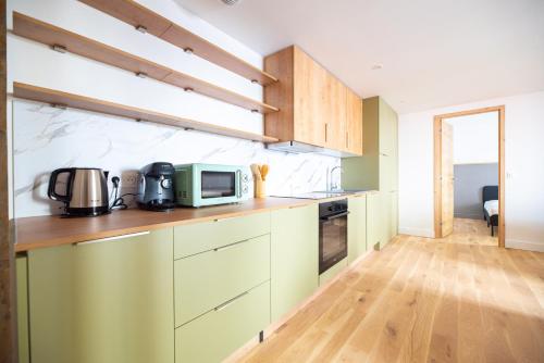 La cuisine est équipée de placards verts et d'un four micro-ondes. dans l'établissement CIA - Les Halles-Rivoli 6P, à Paris