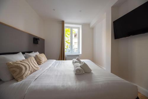 une chambre avec un grand lit blanc avec des serviettes dessus dans l'établissement CIA - Les Halles-Rivoli 6P, à Paris