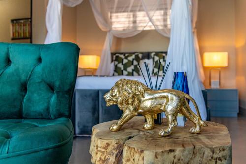 a gold lion statue on a table next to a bed at Ingwenkala Luxury Safari Lodge in Hoedspruit