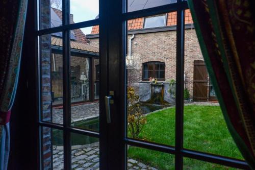 an open window looking out onto a garden from a house at A l'Etang du Trieu in Pecq