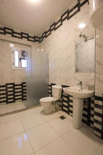 a bathroom with a toilet and a sink at Villa Abo Tarek in Al Aqālitah
