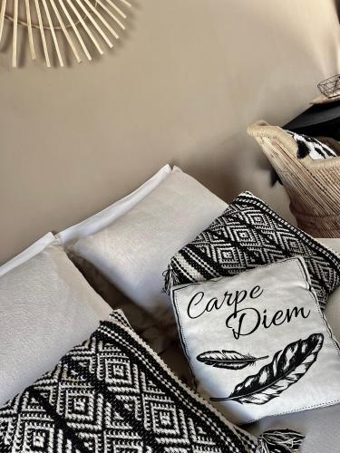 un tas d'oreillers avec les mots cape qui les entourent dans l'établissement La Cabane du Mas Andalou Plage première ligne de mer, à Frontignan