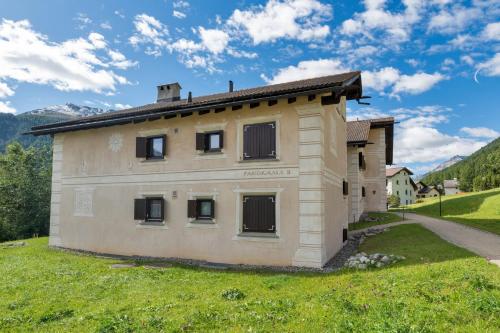 a small building in a field with mountains in the background at Chesa Panorama B - La Punt in La Punt-Chamues-ch