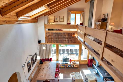 an attic room with a staircase and a table at Chesa Panorama B - La Punt in La Punt-Chamues-ch