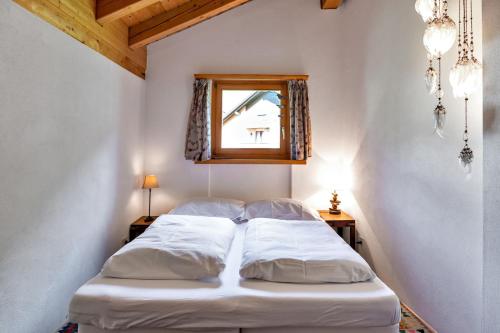 a bed in a room with a mirror and a window at Chesa Panorama B - La Punt in La Punt-Chamues-ch