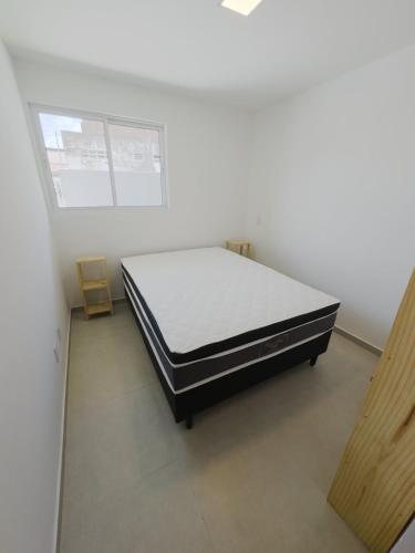 sypialnia z łóżkiem w białym pokoju w obiekcie Condominio Jardim dos Coqueiros térreo w mieście Tamandaré