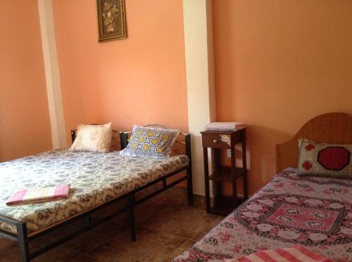 a small room with a bed and a table at Sunshine Hotel in Trincomalee