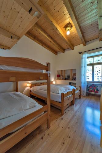 two bunk beds in a room with wooden ceilings at Chesa Roseg - Pontresina in Pontresina