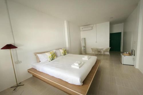 a bedroom with a large white bed in a room at Ban Ye in Phayao