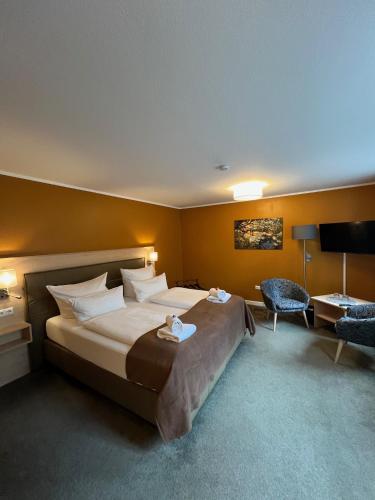 a hotel room with a large bed and a chair at Strandperle B&B in Schwielowsee