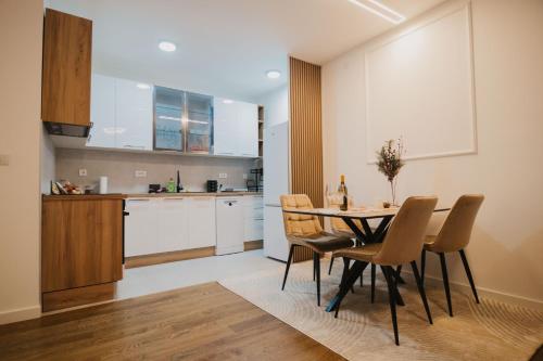 a kitchen and dining room with a table and chairs at Residence Lux apartman in Niš