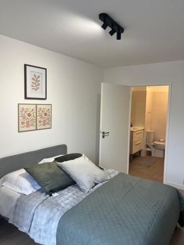 une chambre avec un lit et un ventilateur de plafond dans l'établissement Seemingly Spacious Modern & Bright Chic Paris, à Paris