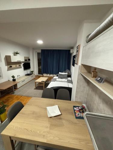 Una habitación con una mesa de comedor y una sala de estar. en 4 Rooms Apartments, en Niš