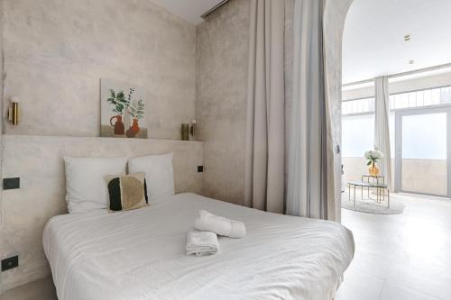 Cette chambre comprend un lit blanc et une grande fenêtre. dans l'établissement Charonne Voltaire Cosy Apartment 4P, à Paris