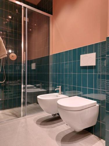 a bathroom with a toilet and a glass shower at The 6 apartments S in Rimini
