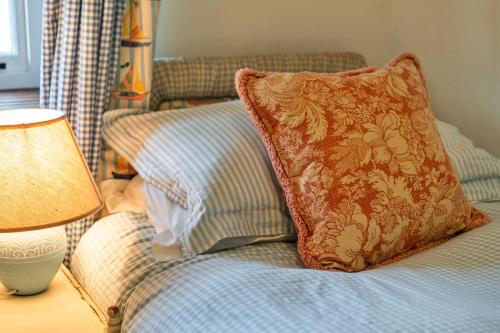 a bed with a pillow and a lamp on a table at Finest Retreats - Whitley in Molland