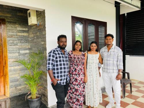 a group of people standing in front of a house at CARMEL HOME STAY in Munnar