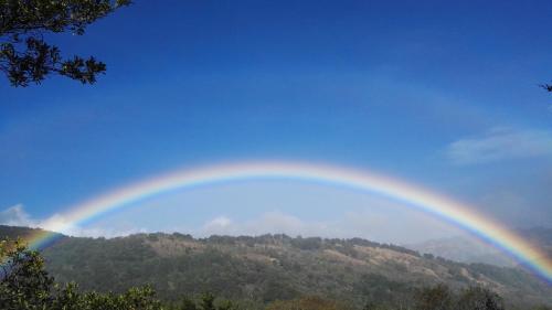 a rainbow in the sky over a mountain at Quinta Galeon Lodge in Santa María