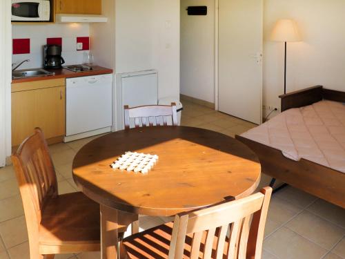 une cuisine et une salle à manger avec une table et des chaises en bois dans l'établissement Apartment Le Domaine de Claire Rive-1 by Interhome, à Prayssac