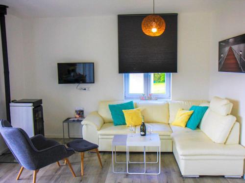 a living room with a white couch and a table at Holiday Home Lakeside Village 47 by Interhome in Frymburk
