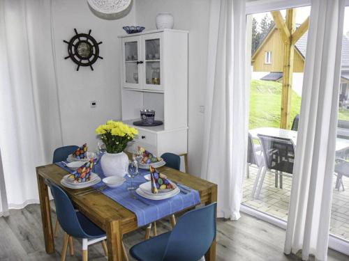 een eetkamer met een tafel en blauwe stoelen bij Holiday Home Lakeside Village 47 by Interhome in Frymburk