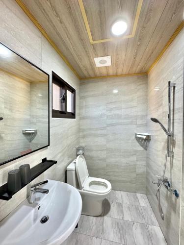 a bathroom with a toilet and a sink and a shower at 柴鹿森苑 鹿港 in Lukang
