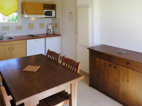 une cuisine avec une table en bois et un échiquier. dans l'établissement Apartment Le Domaine de Claire Rive-3 by Interhome, à Prayssac