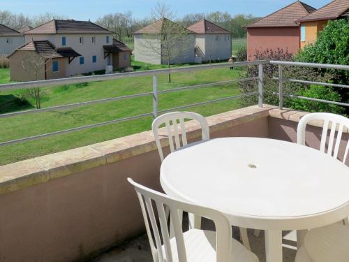 une table blanche et des chaises sur un balcon dans l'établissement Apartment Le Domaine de Claire Rive-3 by Interhome, à Prayssac