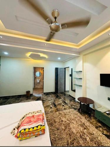 a bedroom with a bed and a ceiling fan at Hotel EM Suites in Nagaon